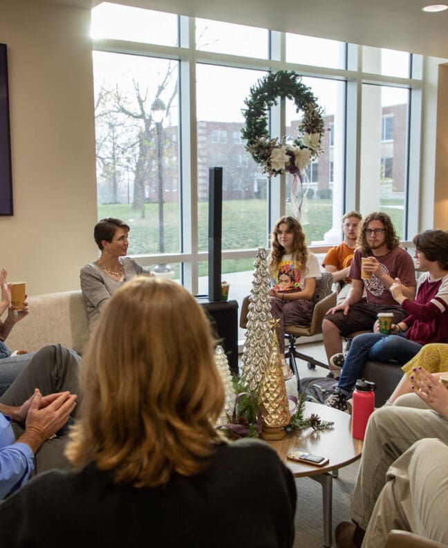 Asbury students sitting with English professors drinking tea