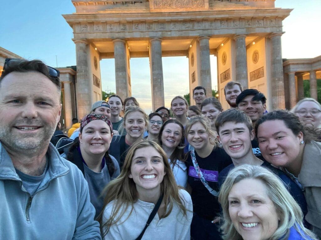 Dr. Nesselrode with students taking a selfie outside a monument on the Human Dignity Tour.