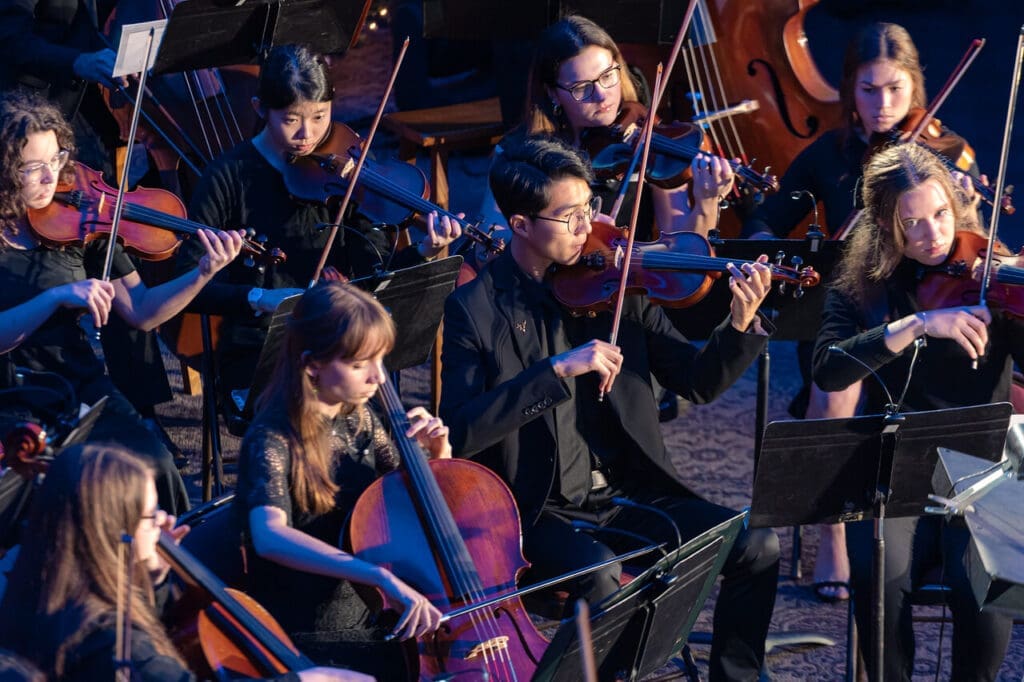 Close up of Asbury's string section in the orchestra during the Songs of Season concert in Hughes Auditorium.