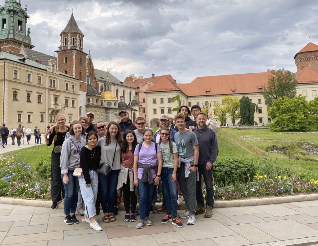 Group of students pose together in a European courtyard