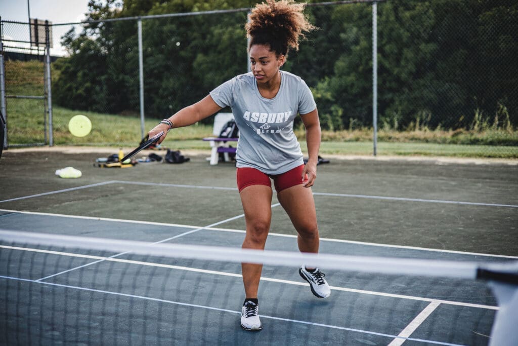 Female student plays pickleball outdoors