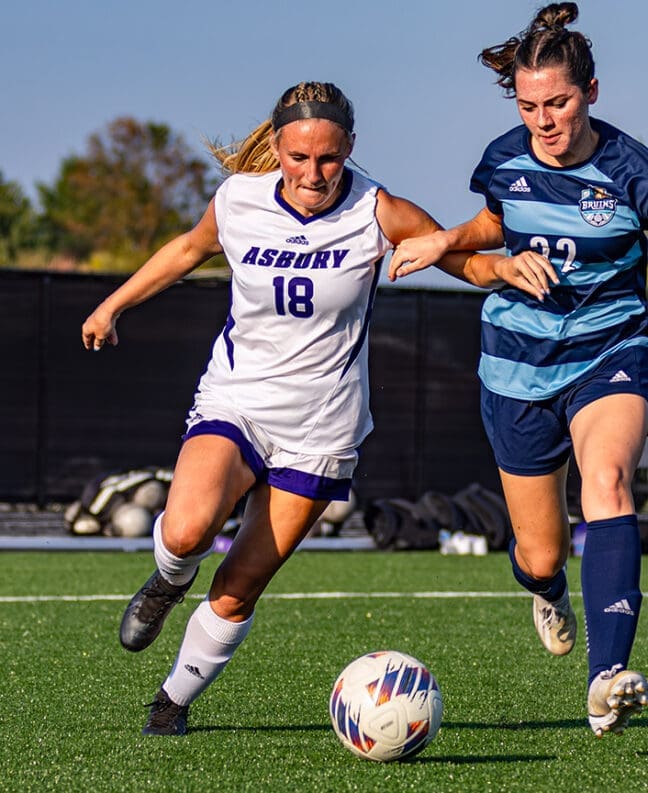 AU women's soccer player runs after the ball on the field