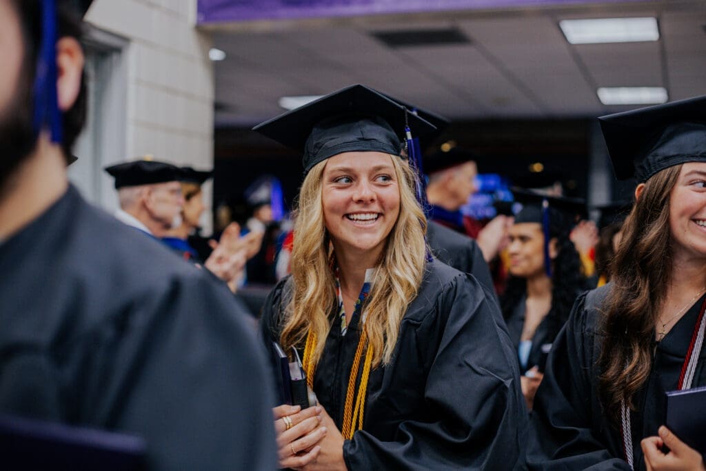 Asbury student at commencement smiling.