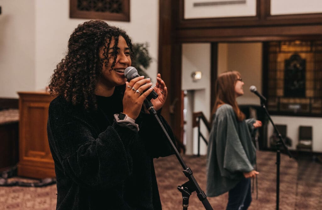 Two females singing for The Asbury Worship Collective (AWC) is the performing arm of the Worship Arts program at Asbury University.