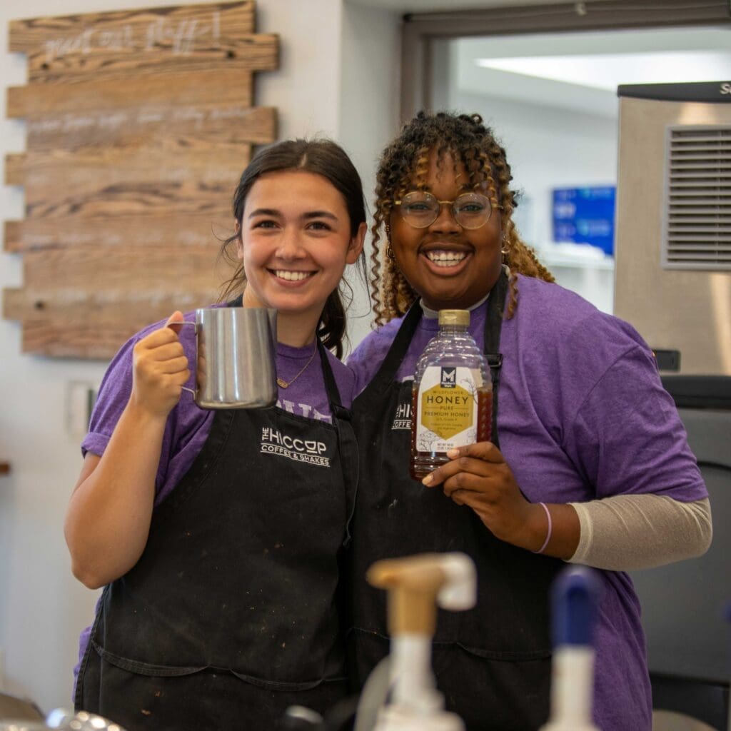 Two girls holding coffee items to represent Asbury University's coffee shop The Hiccup.