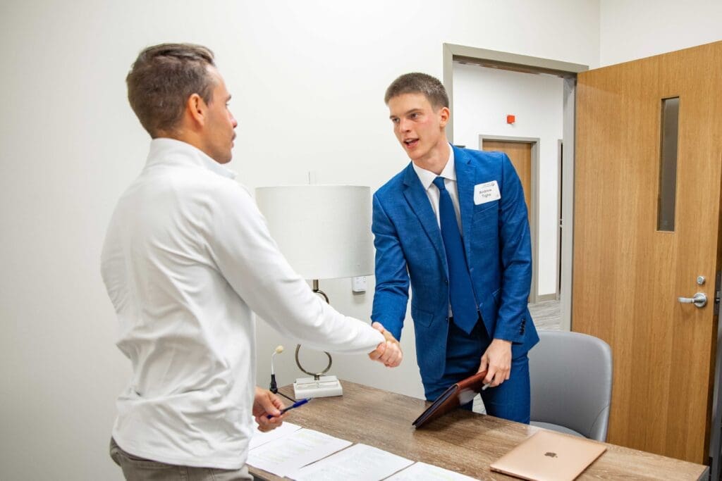 Asbury Sales Competition student shaking hands with professor.