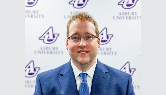 Andy Miller stands in front of an Asbury University backdrop.