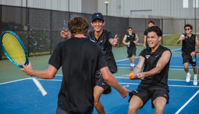 Asbury Men's Tennis Team players celebrate victory.