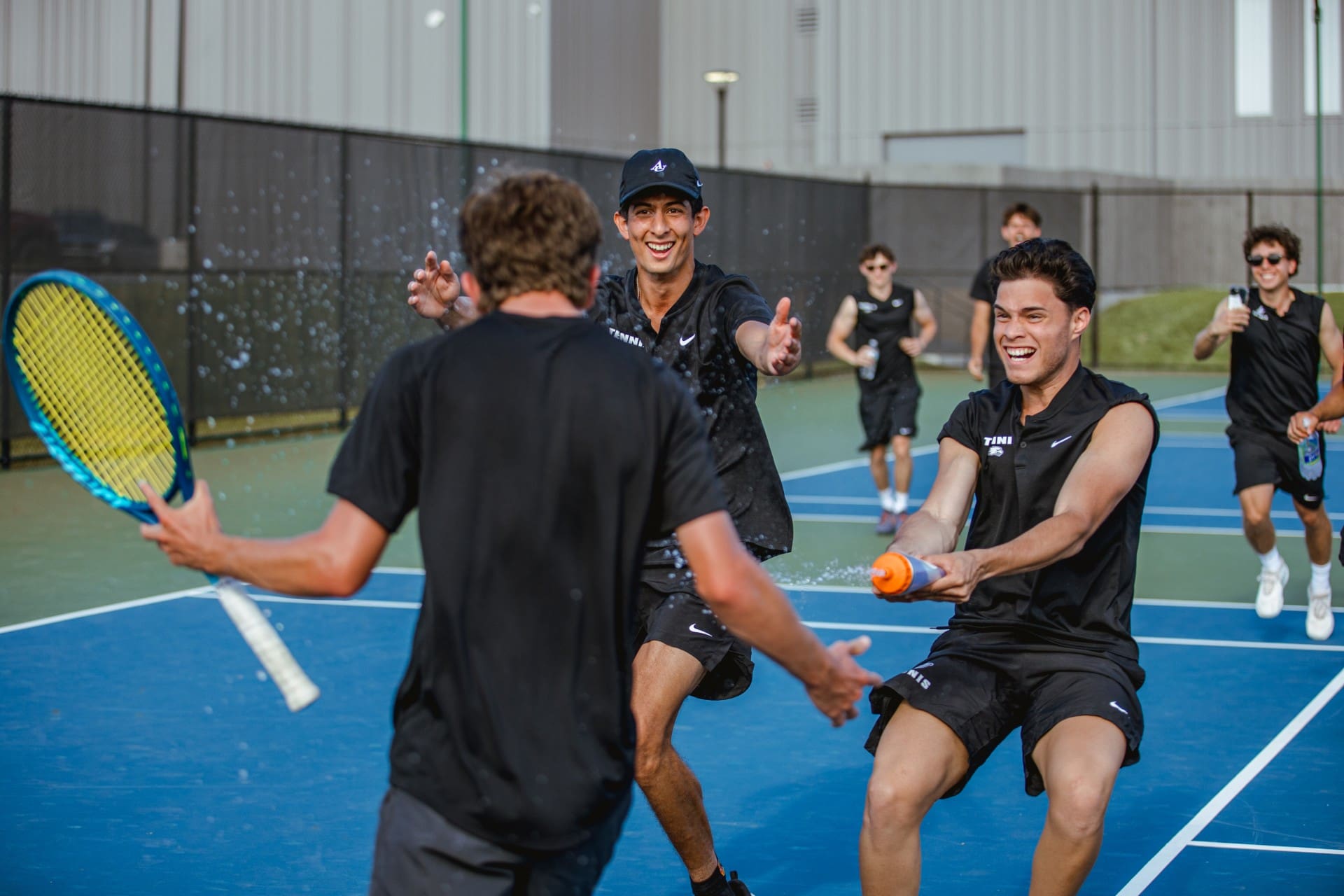 Asbury Men's Tennis Team players celebrate victory.