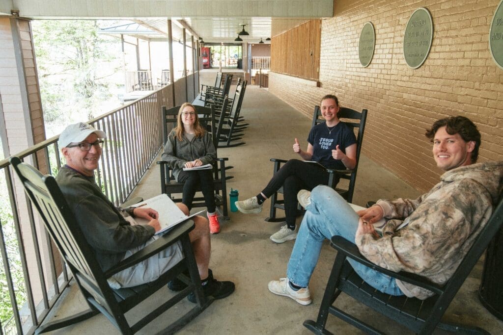 Asbury's Launching Well for Asbury Alumni group on a porch talking.