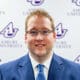 Andy Miller smiles in front of an Asbury University backdrop.